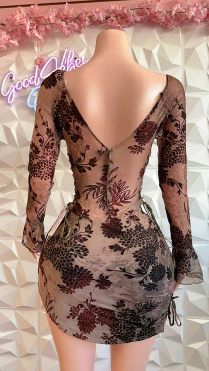 Mannequin wearing a floral dress with a geometric wall and 'Good Vibes' sign in the background